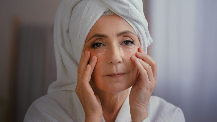 Close up portrait happy senior lady with anti wrinkle skin hydrogel collagen patches under eyes